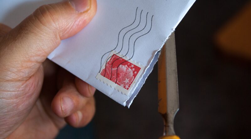 Immagine di una mano che porge una lettera con francobollo